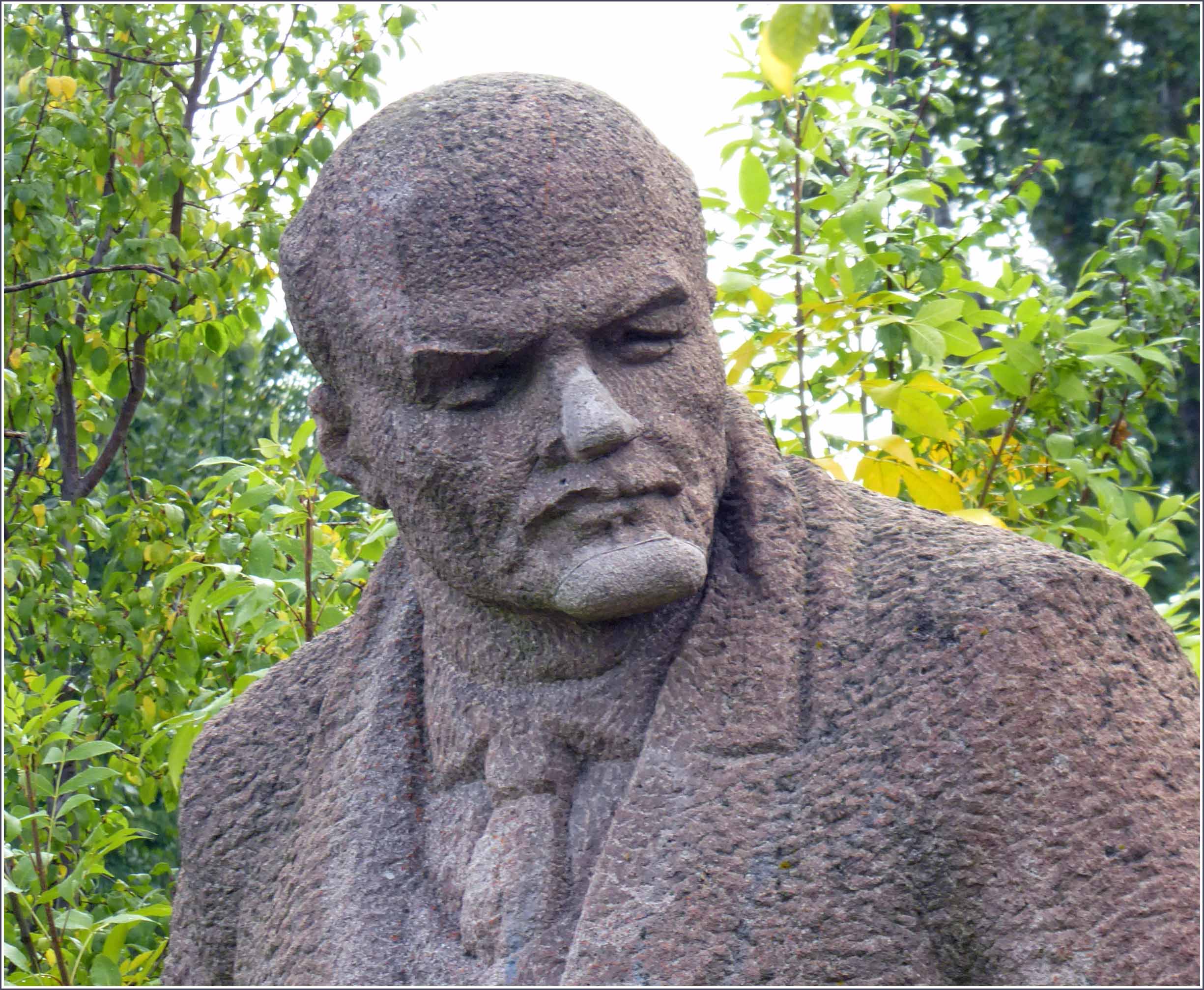 Stone statue of man in an overcoat