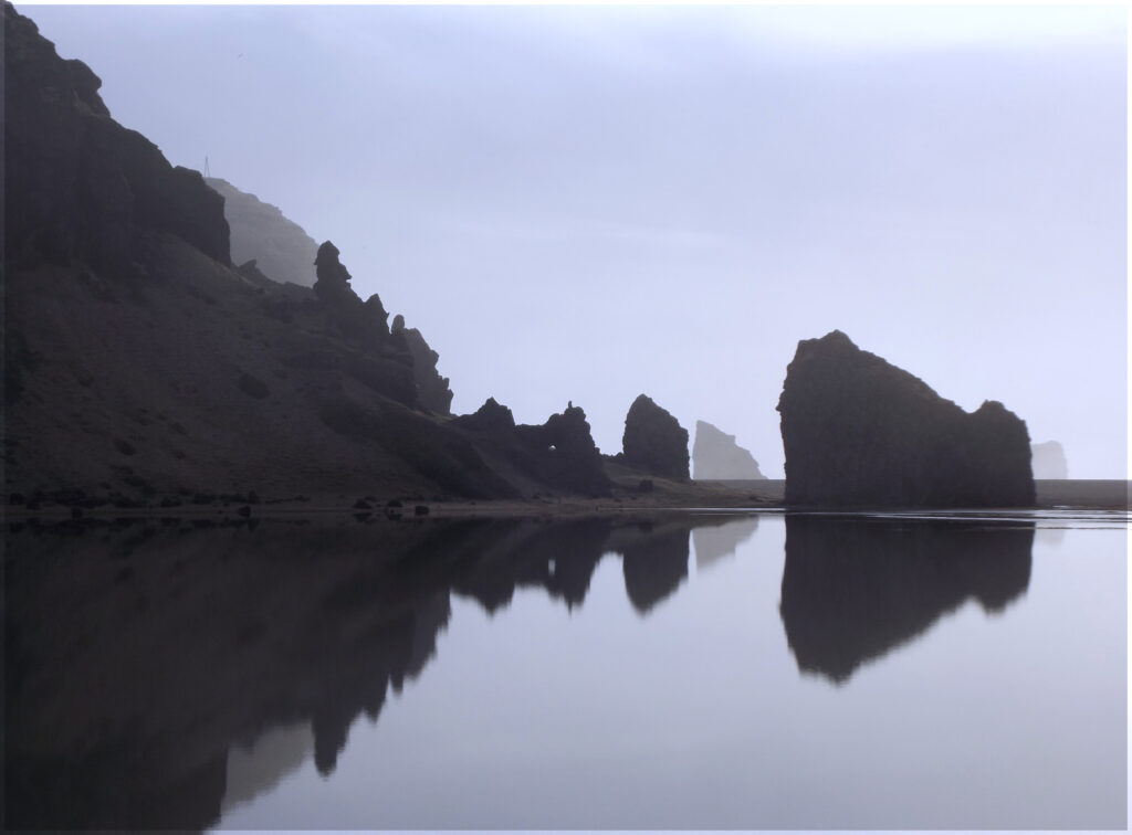Rock stacks reflected in still water