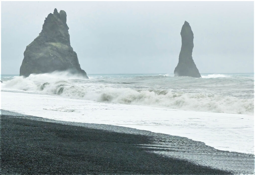 Black beach and offshore rock stacks